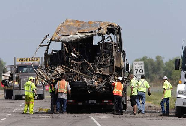 The burned out remains of a tour bus involved in a fiery crash with FedEx truck, sits on a flatbed truck before being taken from the scene, Friday April 11, 2014 in Orland, Calif.  Ten people were killed and dozens injured in the fiery crash between the truck and the bus carrying high school students on a visit to a Northern California College, Thursday.(AP Photo/Rich Pedroncelli)