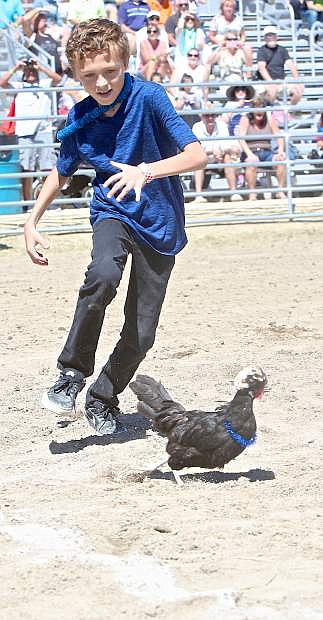 8-year -old Walter Osborne of Dayton tries to get his bird to cross the finish line during the chicken race event in Virginia City Friday.