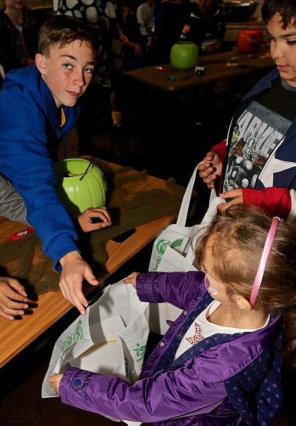 Clint DeWitt, 12, hands out candy to trick-or-treaters for the Carson Elites soccer club Friday at the Food For Thought fun zone in Telegraph Square Friday.