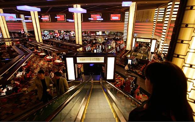 FILE - In this file photo taken Wednesday, Nov. 14, 2007, guests descend an escalator to the main casino floor of the Planet Hollywood Resort &amp; Casino in Las Vegas. While casinos have thousands of cameras watching the gaming floors, entrances and some elevators, cameras are absent in the hallways of the guest room floors where thousands of crimes occur. (AP Photo/Jae C. Hong, File)