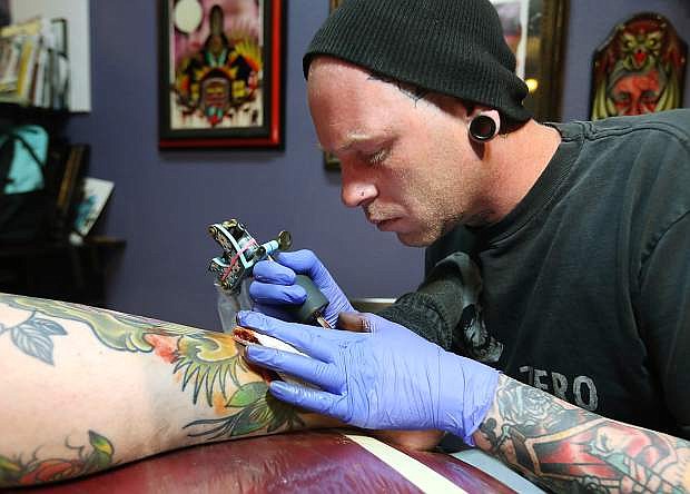 Tattoo artist Jeffery Williford works on Lance Montague at the Ruby Lantern in Carson City on Tuesday. The Ruby Lantern is sponsoring the Tattoo Expo at this week&#039;s Rockabilly Riot event at the Carson City Community Center.