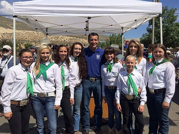 The Carson Valley Shepherds Lamb Club meets Nevada Governor Brian Sandavol during  the ribbon cutting at the NV150  Fair in Carson City. Members of the club are, from left to right,  McKenzie Lewellan, Corie Nalder, Emily Hone, Dominque Groffman, Caroline Jones, Lilly McKinney, Caitlyn Bidart and Leah McKinney.