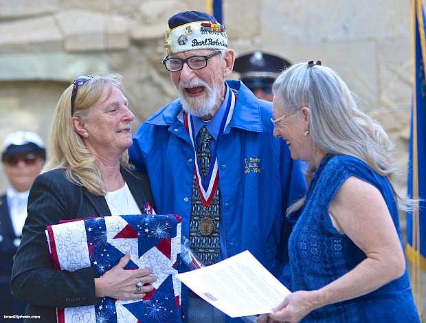 Nevada Appeal photographer  Brad Coman won first place for best news photo for this photo. Charles Sehe receives a quilt from Marsha Strand (right) and Monda Crandellhook (left) from Quilts of Valor on Oct. 14, 2015.