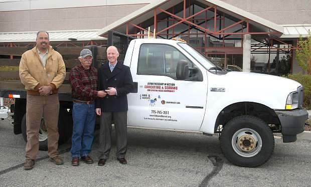 Southwest Gas Vice President, Northern Nevada Division Brad Harris, right, presents the keys to a Ford F-350 1-ton flatbed truck to Doug Brimm, director of Kids and Horses, a therapeutic riding center located in Minden on Tuesday.The truck will be used to transport hay and other bulky materials that are necessary to support the Kids and Horses Ranch. Looking on is Marcus Hernandez, district auto mechanic for Southwest Gas.