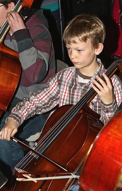 Halen Harrison, 9, plays his Cello at the Christmas Carol String Playalong Friday at the Carson Mall. This was the event&#039;s sixth year.