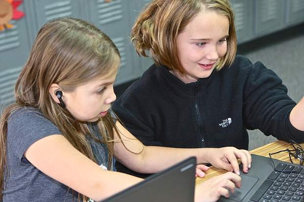 3rd graders Emma Chacon and Neva Mellow work together on their Hour of Code assignment Wednesday at Fritsch Elementary.
