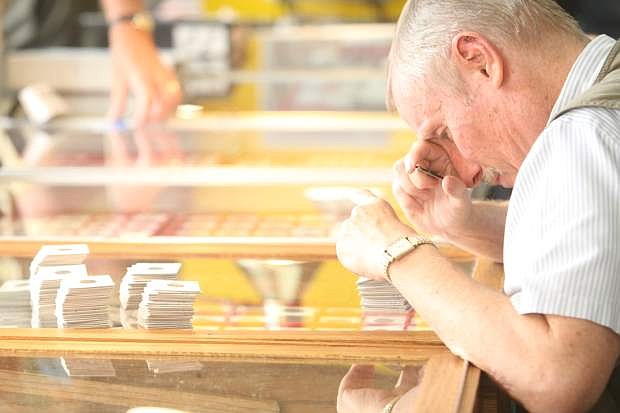 Robert Ekdom of Henderson looks at tokens for sale at the Carson City Mint Coin Show &amp; Fair at the Carson Nugget on Friday. On display at the show is a complete set of small size Nevada Bank Notes and a collection of Carson City Dollars.