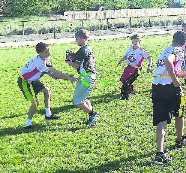 Trevor Marlin of the 49ers pulls the flag of the Saint, Alex Myrehn running while, Braden Rice, top right, and Kory Grist, bottom right, are in pursuit during recent Carson City NFL flag football action.