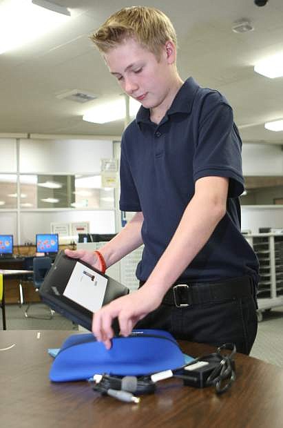 Carson Middle School seventh-grader Tyson Saunders puts his new laptop in its case on Thursday.