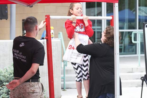 A Cops and Kids attendee tries to do a pull up at the Marine tent Saturday. The Marines were there to promote their organization at the event and interact with the community.