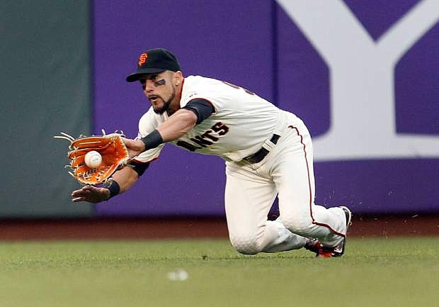 San Francisco Giants left fielder Andres Torres makes a diving catch on a hit by Chicago Cubs&#039; Nate Schierholtz during the sixth inning of a baseball game on Saturday, July 27, 2013, in San Francisco. (AP Photo/Tony Avelar)
