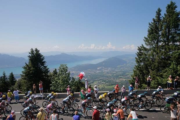the pack passes Annecy lake, background, during the 20th stage of the Tour de France cycling race over 125 kilometers (78.1 miles) with start in in Annecy and finish in Annecy-Semnoz, France, Saturday July 20 2013. (AP Photo/Laurent Cipriani)