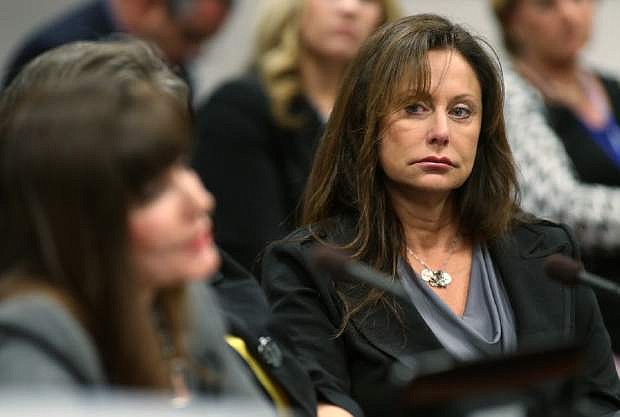 Bridgette Denison listens as Jayann Sepich testifies on a bill that would require collection of a DNA sample from people arrested on felony charges, during a hearing at the Legislative Building in Carson City, Nev., on Thursday, May 9, 2013. The bill, also known as Brianna&#039;s Law, is named after Denison&#039;s 19-year-old daughter who was murdered in Reno in 2008. (AP Photo/Cathleen Allison)