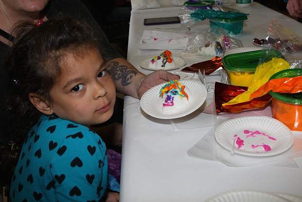 Five-year-old Rayka Jarrett makes a sugar skull in the craft area at the Nevada State Museum for Day of the Dead.