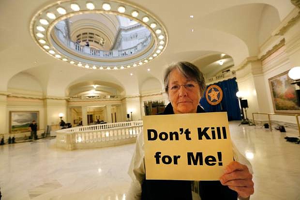 Margaret Cox with Oklahoma Coalition Against the Death Penalty holds a sign protesting the death penalty at the State Capitol in Oklahoma City, Tuesday April 29, 2014. Oklahoma prison officials halted the execution of an inmate after the delivery of a new three-drug combination on Tuesday failed to go as planned. (AP Photo/The Oklahoman, Steve Gooch)