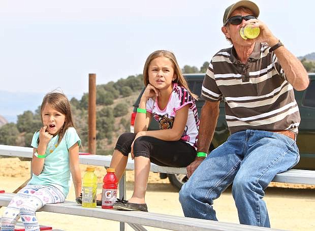 Emma Forest-Crawford, 6, of Reno and her 9-year-old sister Sopia take in the camel racing with their grandfather Michael Crawford of Myrtle Creek, Or. in Virginia City Friday.