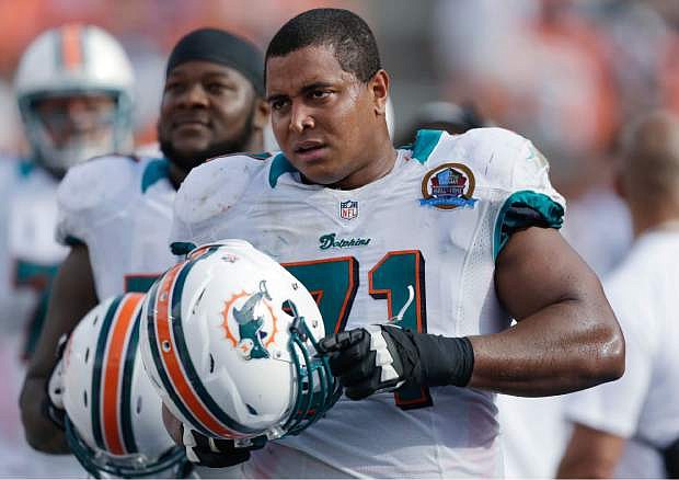 In this Dc. 16, 2012, photo, Miami Dolphins tackle Jonathan Martin (71) stands on the sidelines during the Dolphins&#039; NFL football game against the Jacksonville Jaguars in Miami. Martin, the offensive tackle at the center of the Dolphins&#039; bullying scandal, has been traded to the San Francisco 49ers. The Dolphins announced the deal Tuesday night, March 11, 2014, on the first day of NFL free agency. Martin&#039;s move cross country brings him back to the Bay Area to be reunited with his former Stanford coach, Jim Harbaugh. (AP Photo/Wilfredo Lee)