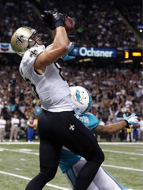 New Orleans Saints tight end Jimmy Graham (80) pulls in a touchdown reception over Miami Dolphins cornerback Jamar Taylor (22) in the first half of an NFL football game in New Orleans, Monday, Sept. 30, 2013. (AP Photo/Bill Haber)