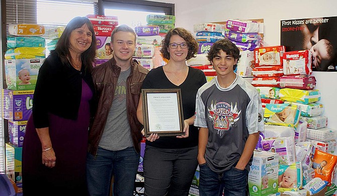Ron Wood Family Resource director Joyce Buckingham, Carson High School senior Adam Maw, Nicki Hendee and Carson High senior Brandon Basa stand with more than 14,000 diapers and 34,000 baby wipes and proclamation issued by Mayor Robert Crowell  for Diaper Need Awareness week. Hendee and the Carson High School government classes held a diaper drive to help provide women in the community with free diapers. The three dropped off the diapers to the Ron Wood Center Thursday morning.
