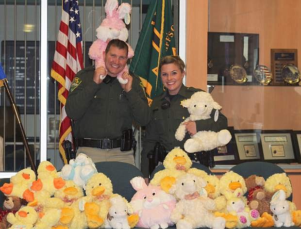 Carson City Sheriff&#039;s deputies Trotter and Chrzanowski pose with some of the two dozen stuffed animals donated to the office on Friday night.