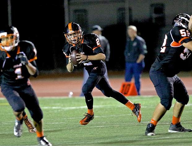 Douglas quarterback Bryce James (2) rolls to his right in a 21-19 win over Manogue at home Friday night.