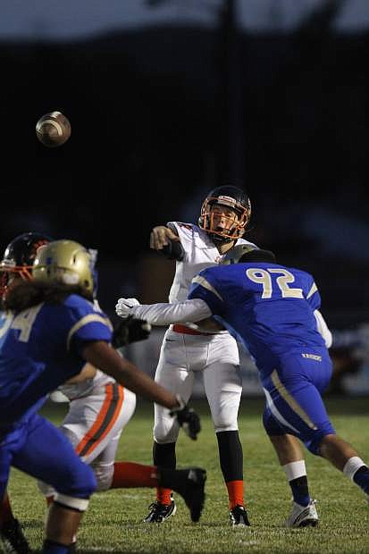 Douglas quarterback Bryce James fires off a pass against Reed Friday night in Sparks.