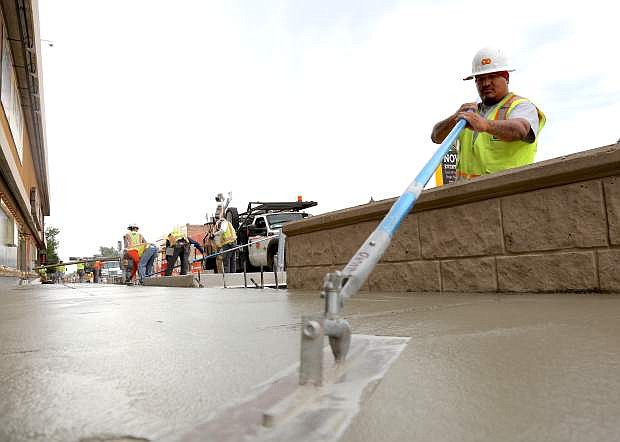 Rico Mora of Q&amp;D Construction does finish concrete work on a sidewalk in front of the Carson Nugget.