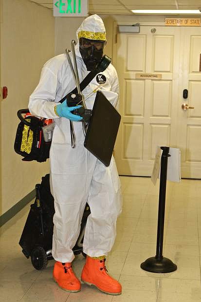 Staff Sergeant Richard Jager is seen in a hazmat suit bringing monitoring equipment into the basement of the State Capitol Wednesday morning during a 92nd Civil Support Team drill.
