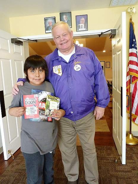 Tahoe-Douglas Elks Lodge recently provided books to 29 students at C.C.Meneley Elementary School. Student were each given three books selected by the school specifically for the child. Each student also received a challenging puzzle, a stuffed animal, cards and additional books. The effort was funded by Elks member donations and a Beacon Grant from the Elks National Foundation in Chicago. Shown receiving books fourth grader Eli Frank and Elks Past President John Louritt.