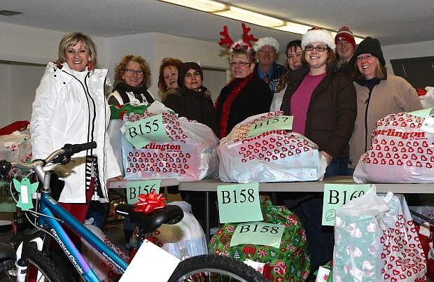Empire Elementary office manager and &#039;Angel Tree&#039; coordinator Denise DiMarzo, left, poses with other school employees and volunteers Saturday at the school&#039;s warehouse near the airport. The group will distribute food and gifts to 100 families and 325 children during their annual Christmas event.