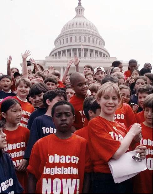 FILE - In this Wednesday, May 20, 1998 file photo, Olympic gold medalist Tara Lipinski, right, stands with school children in an anti-tobacco rally on Capitol Hill in Washington. The rally was sponsored by the Campaign for Tobacco-Free Kids. (AP Photo/Dennis Cook)
