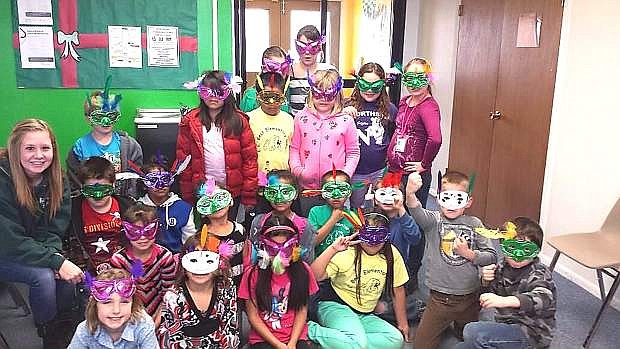 Children at the Fallon Youth Club sport masks they created during an arts and crafts session.