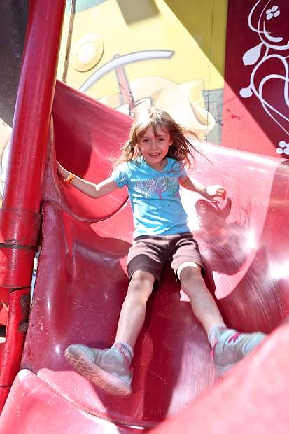 Rowan Behrens, 7, comes down the slide out of Diamond Lil&#039;s funhouse Friday at the fair.