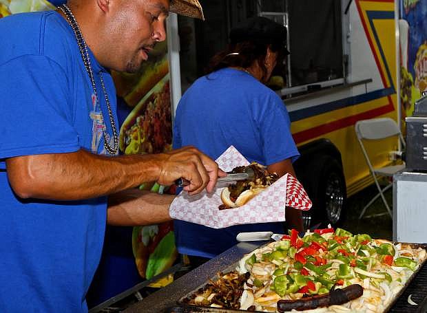Hot Doggin&#039; Eddie Barrera of Sacramento serves up a bacon-wrapped hot dog Thursday at the fair.
