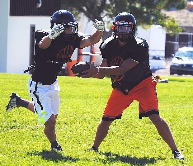 Fernley quarterback Kevin Montgomery, right, fakes a handoff to running back Devin Archer during practice last week.