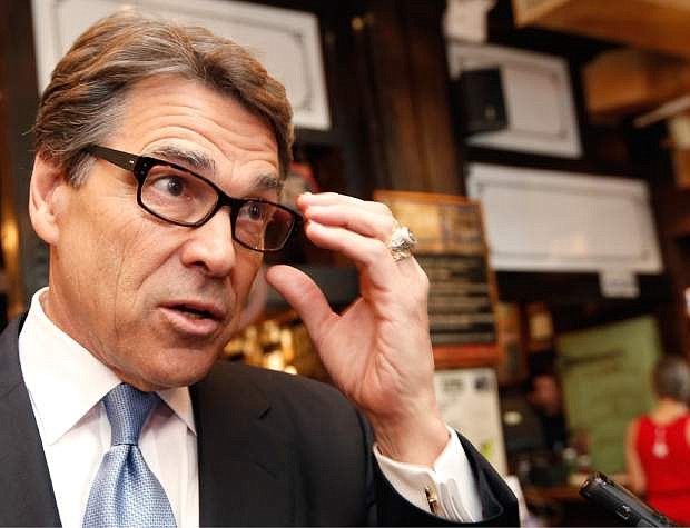 FILE - In this April 23, 2014 file photo, Texas Gov. Rick Perry speaks to the media after meeting with business owners in New York. A Texas land dispute has Perry and the Republican candidate favored to replace him, Greg Abbott, decrying the same federal agency currently embroiled in an armed standoff in Nevada. (AP Photo/Kathy Willens, File)