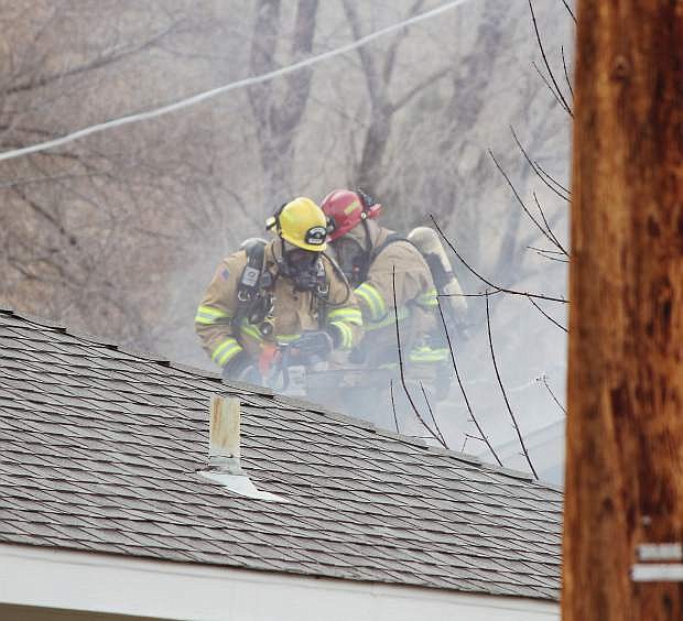 Firefighters work to put out a fire at a house on Fifth Street Thursday.