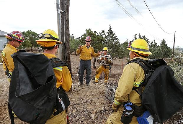 Carson City Fire Capts. Mike Santos, left, and Jason Danen, center, conduct wildland fire training with new recruits in Carson City, Nev., on Wednesday, Sept. 30, 2015. The crew was working with the department&#039;s seasonal wildland firefighters to practice thinning brush, running hose lines and honing skills for protecting homes from fire.