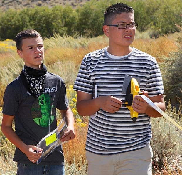 Freshmen biology students Adam Daniels, left, and Edson Lemus make some measurements in the area of the Waterfall Fire Thursday.