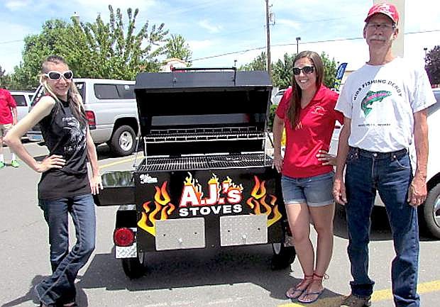 Bob Ellis has been involved with the Kids&#039; Fishing Derby since its inception 26 years ago, and his daughters, Tiffany Ellis, left, and Heather Gertsch will again be working the event on Friday and Saturday at Lampe Park. Here, they are pictured with one of the grand prize raffle items, a WoodMaster barbeque that was donated by A.J. Stoves in Gardnerville.