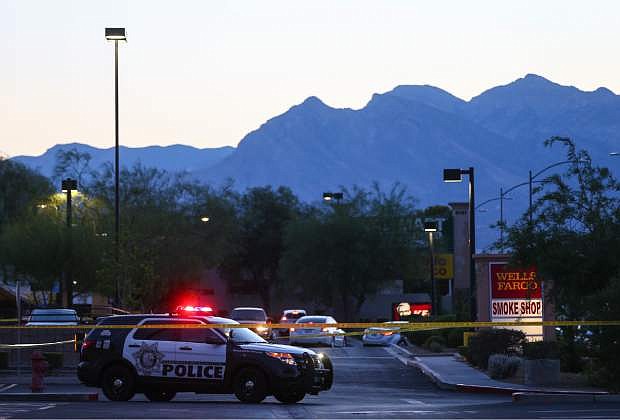 In this photo taken Wednesday, June 29, 2016, Las Vegas police investigate a homicide outside of a Walgreens at Lake Mead and Jones Boulevards in Las Vegas. A man chased and gunned down his wife outside the drug store and killed their three children at an apartment in Las Vegas before apparently shooting himself, leaving five members of a family dead, authorities said Thursday, June 30, 2016.  (Chase Stevens/Las Vegas Review-Journal via AP)