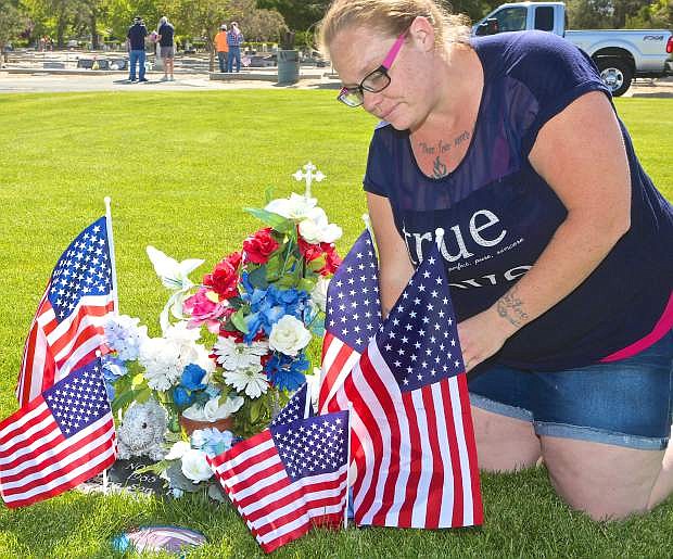 Sharry Beeler of Carson City places flags and flowers on Army SSG Chris Rosales&#039; resting place Friday at Lone Mountain Cemetery.