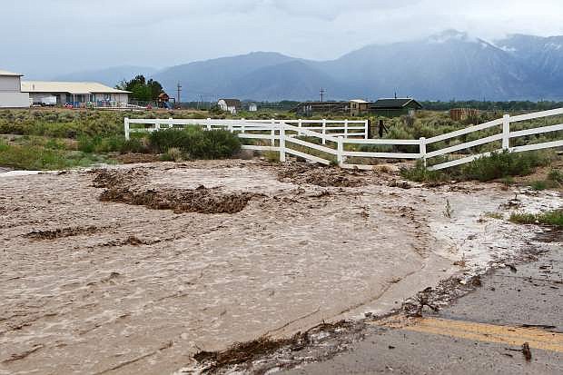 Flash flood waters pour across East Valley Rd. just north of Pinenut Rd. in south Gardnerville Wednesday afternoon after the Pinenut Range to the east received heavy rain from remnants of tropical storm Blanca. Further east, Yerington reported 2 inches of rain in 20 minutes.