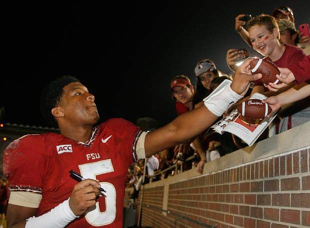 FILE - In a Saturday, Nov. 23, 2013 file photo, Florida State quarterback Jameis Winston (5) signs autographs after an NCAA college football game against Idaho, in Tallahassee, Fla. Its handling of sexual assault allegations against Florida State quarterback Winston is just the latest controversy to hit the Tallahassee Police Department. A handful of grand juries recently have issued scathing reports about how some officers have conducted themselves in the line of duty.(AP Photo/Phil Sears, File)