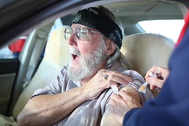 Greg Regan reacts to his flu shot on Saturday morning during the drive-through flu clinic at the Carson City corporate yard.