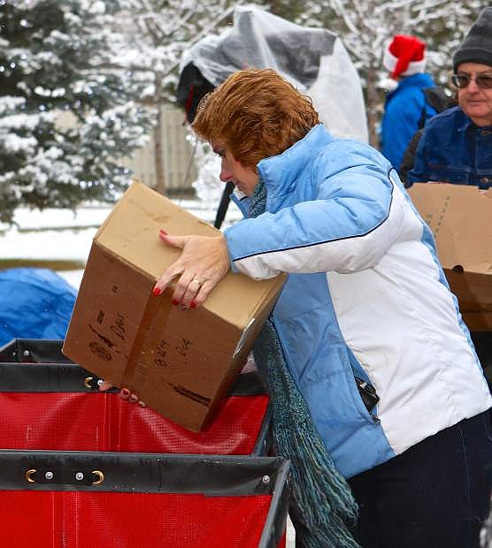 Advocates volunteer April Romo loads a box of donated food into a container Friday morning at the Governor&#039;s Mansion.