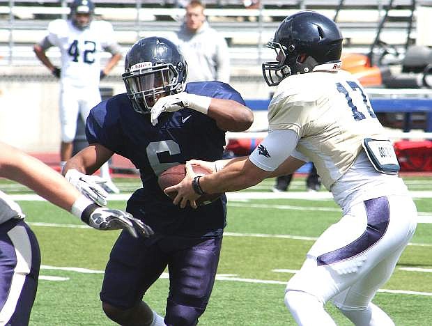Nevada quarterback Cody Fajardo fakes the hand off to running back Don Jackson in Saturday&#039;s annual Silver and Blue Game at Mackay Stadium in Reno.