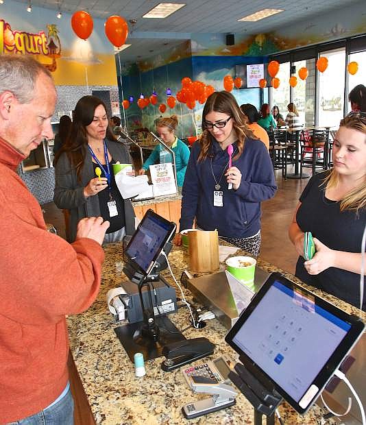 Yogurt Beach owner Jason Fairman rings-up NEIS employees during a fundraiser for Maya Morrison who is being treated for Leukemia. Yogurt Beach will donate 30% of its profits Friday to help Maya&#039;s family.