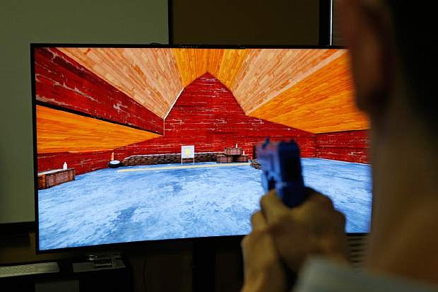 In this May 29, 2015, photo, Vice President of Game Development Baron Giuffria demonstrates a first person skill based gambling game prototype by G2 Game Design in Las Vegas. The player uses a gun to shoot much like a video game. (AP Photo/John Locher)