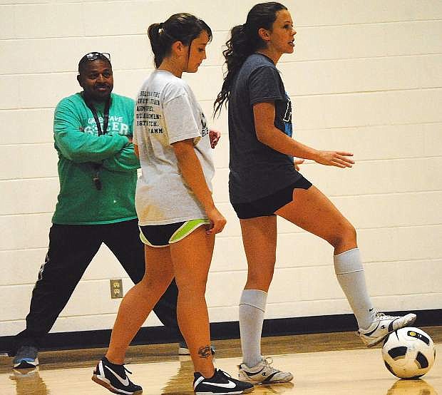 Fallon girls soccer coach Kelly Spicer, left, watches as senior Monica Mills, right, outlines a drill with Haley Sanches during Monday&#039;s practice.
